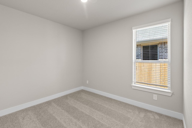 carpeted spare room featuring baseboards
