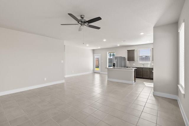 unfurnished living room featuring a ceiling fan, baseboards, recessed lighting, and light tile patterned floors