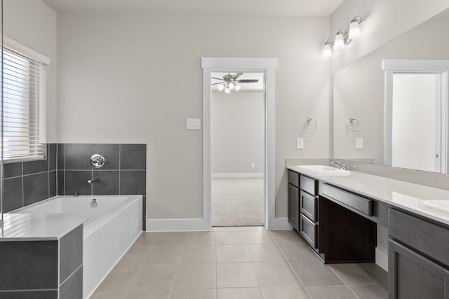 bathroom with tile patterned floors, a sink, double vanity, ceiling fan, and a garden tub