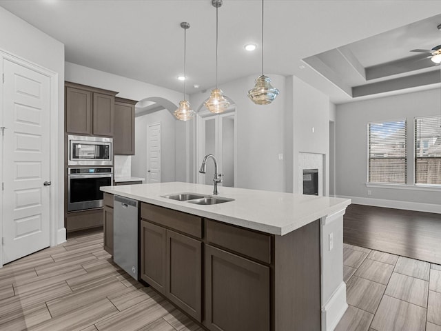 kitchen featuring sink, hanging light fixtures, an island with sink, ceiling fan, and stainless steel appliances