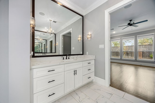 bathroom featuring ornamental molding, ceiling fan with notable chandelier, and vanity