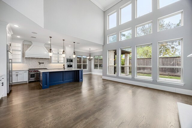 living room with crown molding, dark wood-type flooring, sink, and a high ceiling