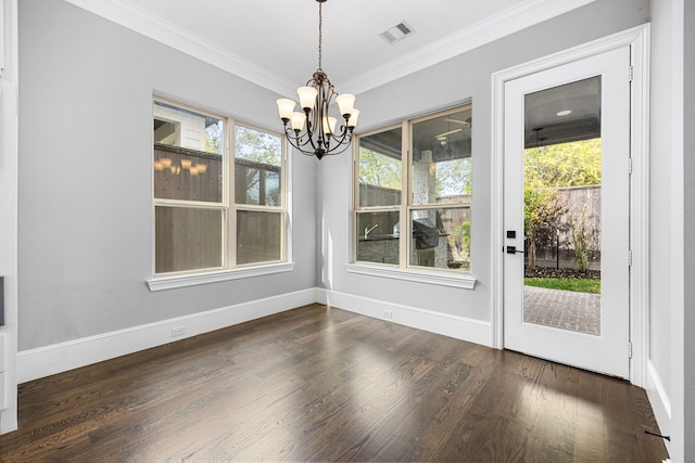 unfurnished dining area with crown molding, a healthy amount of sunlight, dark wood-type flooring, and a chandelier