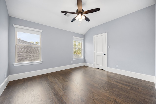 spare room with vaulted ceiling, dark hardwood / wood-style floors, and plenty of natural light