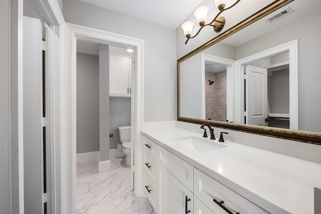 bathroom featuring vanity, a notable chandelier, and toilet