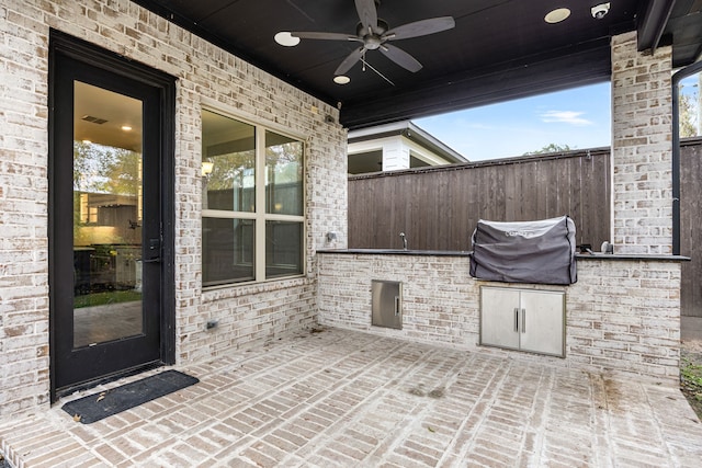 view of patio featuring grilling area, ceiling fan, and exterior kitchen