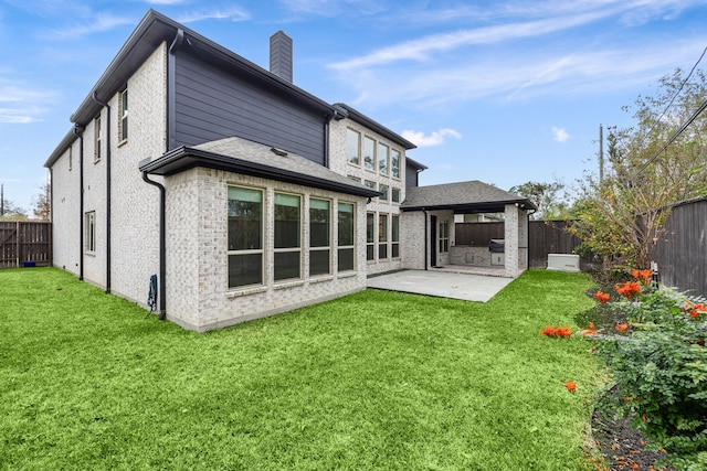 rear view of house with a patio area and a lawn