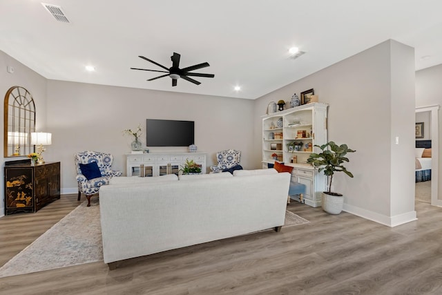 living room with ceiling fan and light hardwood / wood-style floors