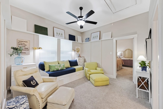 living area featuring light colored carpet and ceiling fan