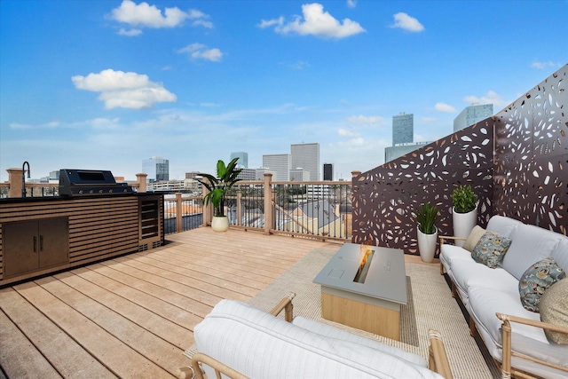 wooden deck featuring a view of city, an outdoor living space, and area for grilling