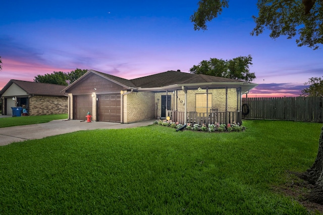 ranch-style house with a garage, covered porch, and a lawn