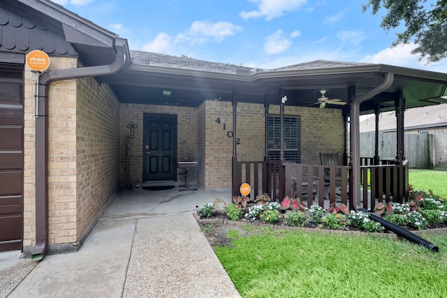 view of exterior entry with ceiling fan and a porch