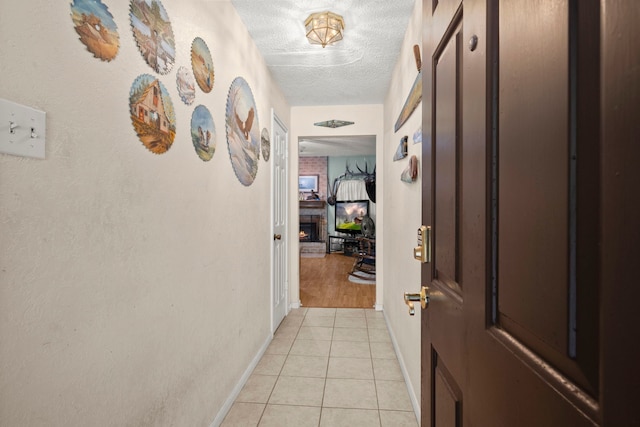 hallway with light tile patterned floors and a textured ceiling