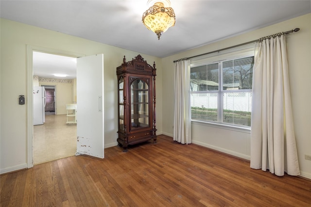 spare room with wood finished floors and baseboards