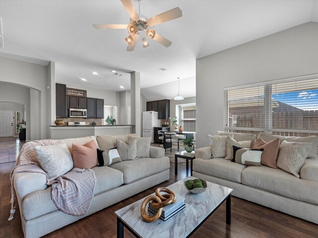 living room with ceiling fan, lofted ceiling, and dark hardwood / wood-style flooring