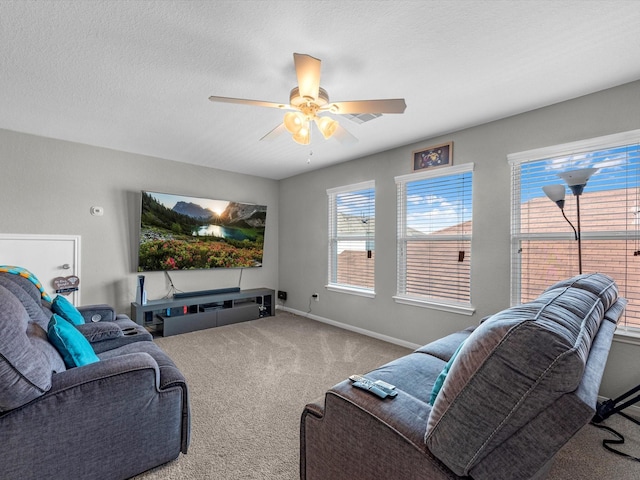 living room with a textured ceiling, ceiling fan, and carpet