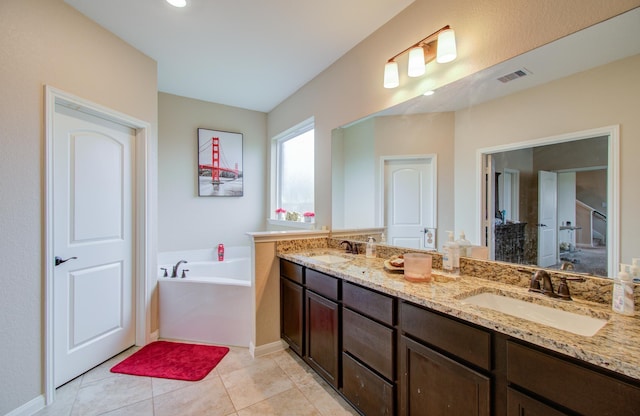 bathroom featuring vanity, a bath, and tile patterned floors