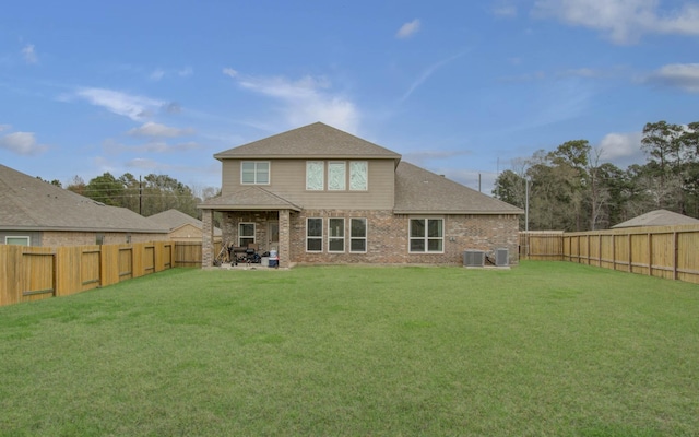 rear view of property with a yard and central AC