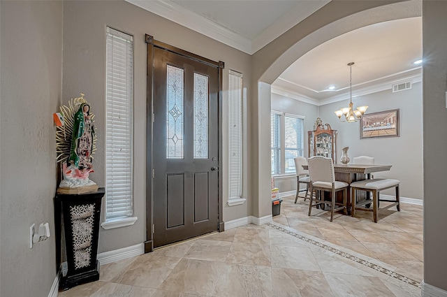 entryway with ornamental molding and a notable chandelier