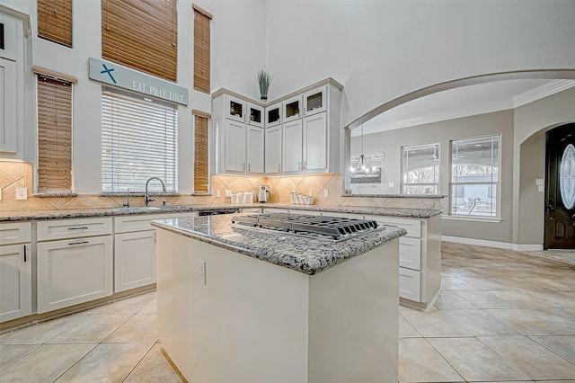 kitchen featuring light stone counters, white cabinetry, a center island, and light tile patterned flooring