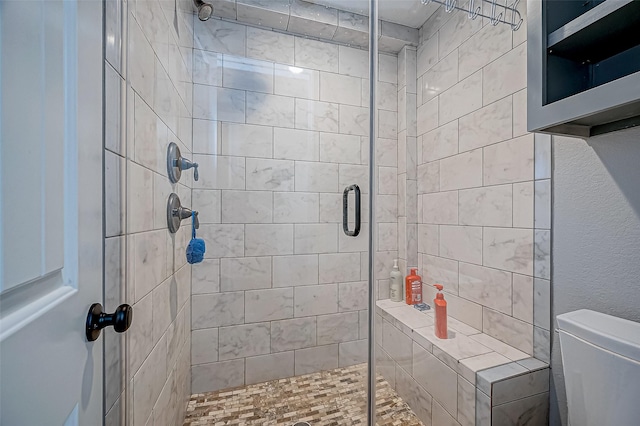 bathroom with toilet and a shower with shower door