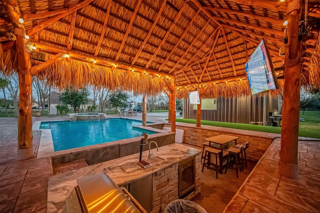 view of swimming pool featuring an outdoor bar, a gazebo, a patio, an in ground hot tub, and an outdoor kitchen