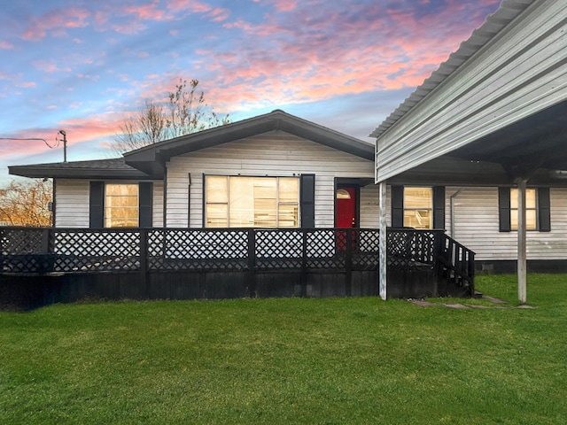 back house at dusk featuring a yard