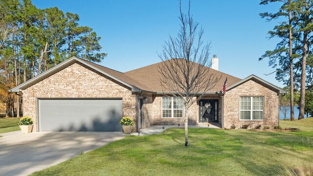 ranch-style house with brick siding, a chimney, a front yard, a garage, and driveway