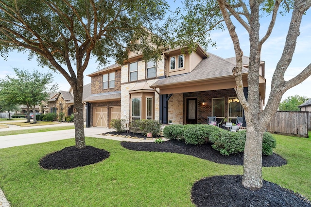 view of front of home with a porch, a garage, and a front lawn