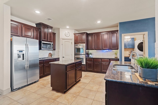 kitchen with sink, a kitchen island with sink, backsplash, dark brown cabinets, and stainless steel appliances