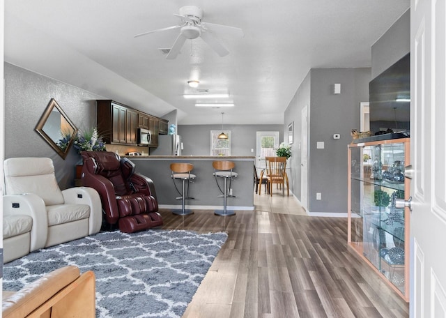 living room featuring hardwood / wood-style flooring and ceiling fan