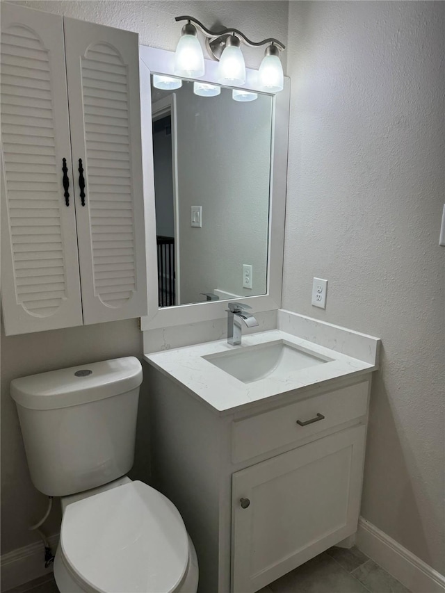 bathroom featuring vanity, tile patterned floors, and toilet