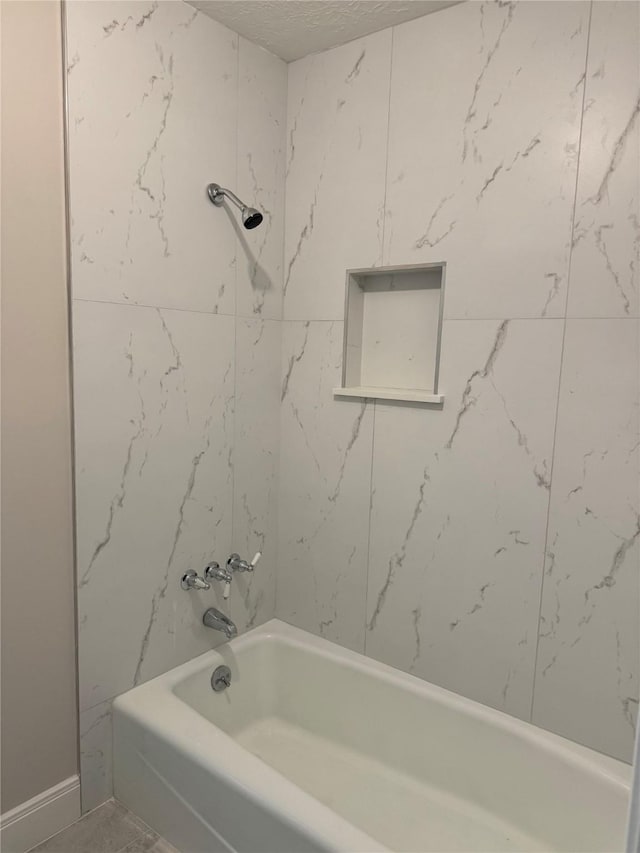 bathroom featuring tiled shower / bath