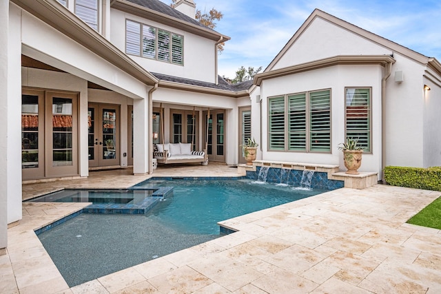 rear view of house featuring pool water feature, a swimming pool with hot tub, a patio, and french doors