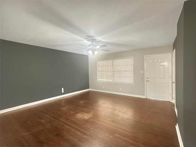 empty room featuring dark wood-type flooring and ceiling fan