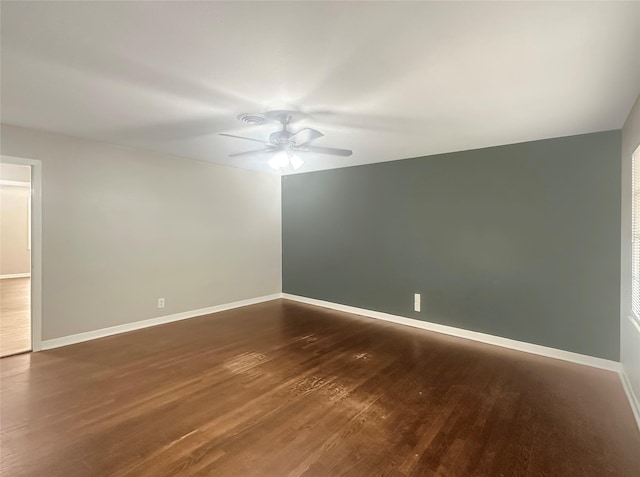 spare room with dark wood-type flooring and ceiling fan