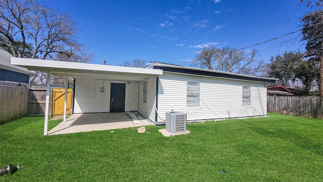 back of house with central AC unit, a lawn, a patio area, and a fenced backyard