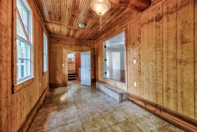 hallway featuring wood ceiling and wood walls