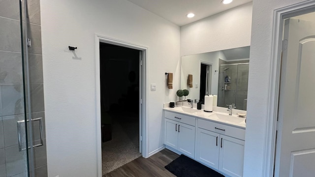 bathroom featuring hardwood / wood-style flooring, vanity, and walk in shower