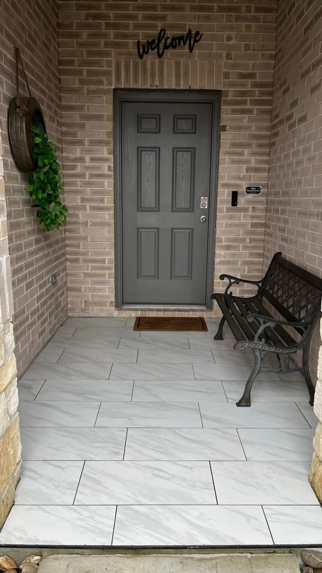 view of exterior entry featuring covered porch