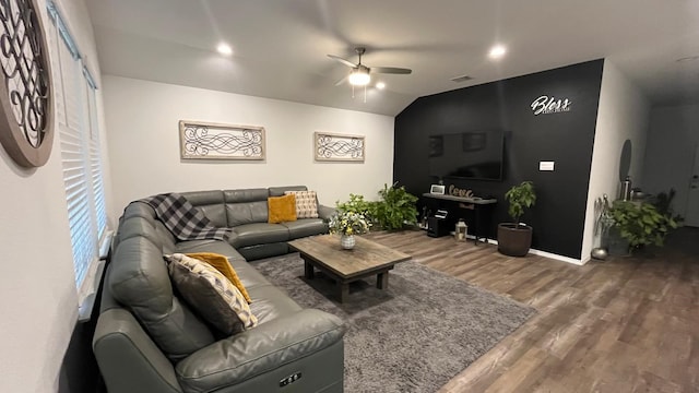 living room with lofted ceiling, hardwood / wood-style flooring, and ceiling fan