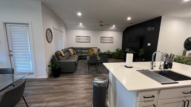 kitchen with dark wood-type flooring, sink, white cabinetry, light stone counters, and ceiling fan