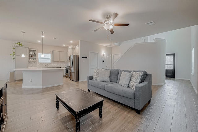 living room with ceiling fan and light wood-type flooring