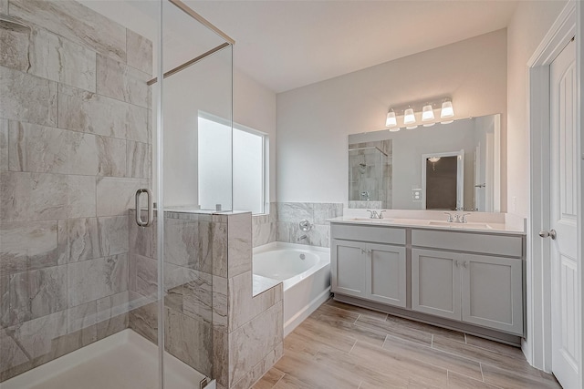 bathroom with vanity and independent shower and bath