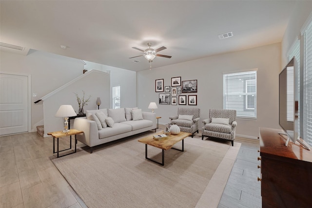 living room with ceiling fan and light hardwood / wood-style flooring