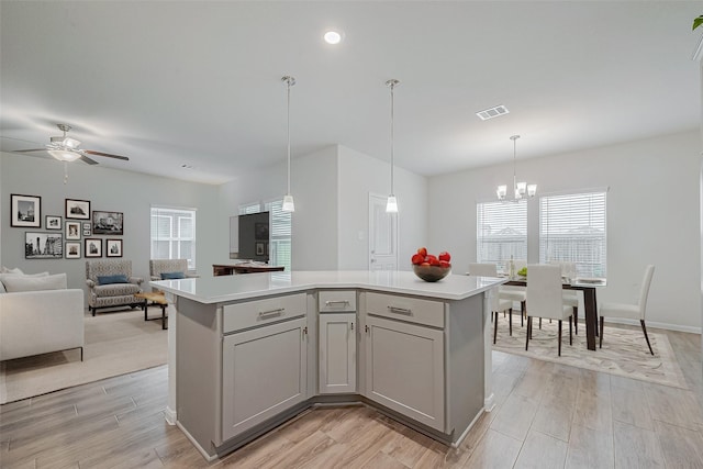 kitchen featuring plenty of natural light, a center island, pendant lighting, and light hardwood / wood-style floors