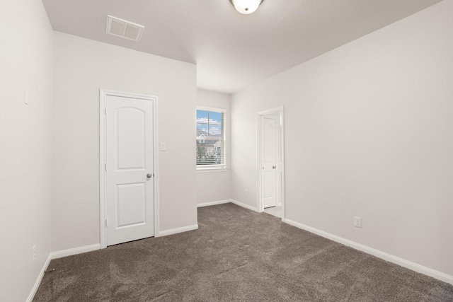 unfurnished bedroom with dark carpet