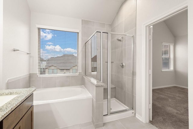 bathroom featuring tile patterned flooring, vanity, a healthy amount of sunlight, and plus walk in shower