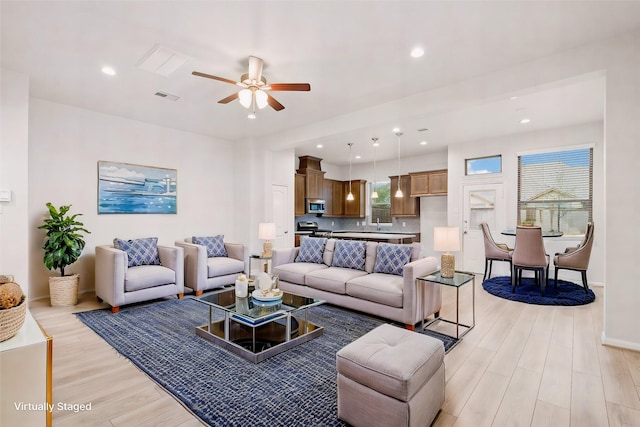 living room with ceiling fan and light wood-type flooring