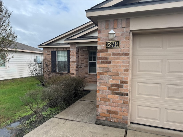 doorway to property featuring a garage and a yard